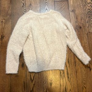 A cream, fuzzy sweater